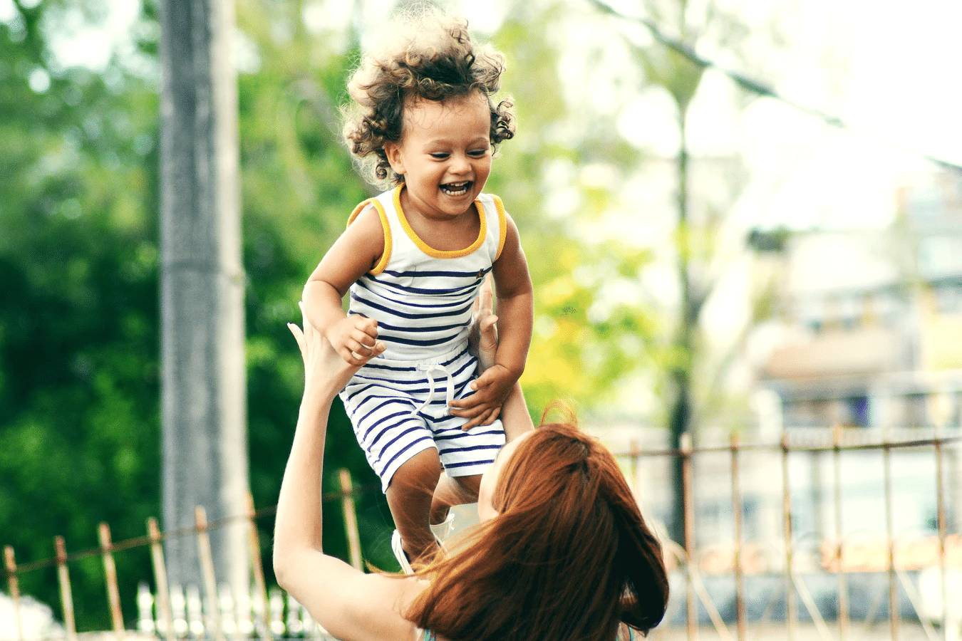 enfant souriant avec sa mère dans le jardin