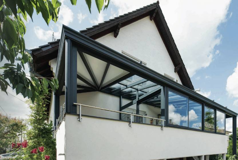 Véranda moderne en verre attachée à une maison blanche