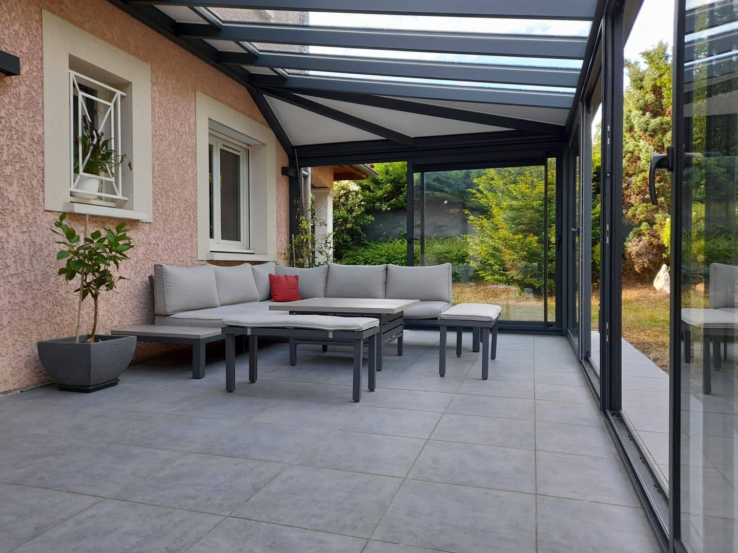 Canapé et table dans la véranda avec vue sur le jardin