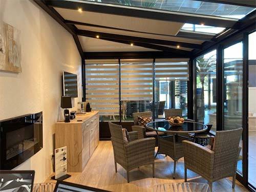 Véranda moderne avec mobilier de jardin et grande luminosité