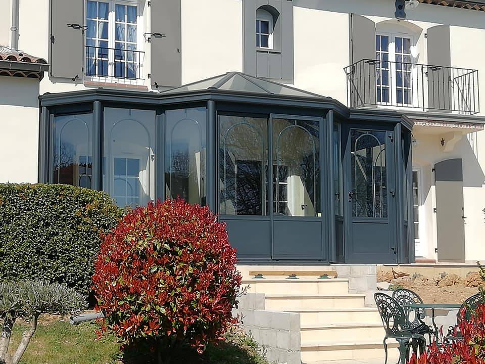 Véranda élégante en aluminium attachée à une maison moderne