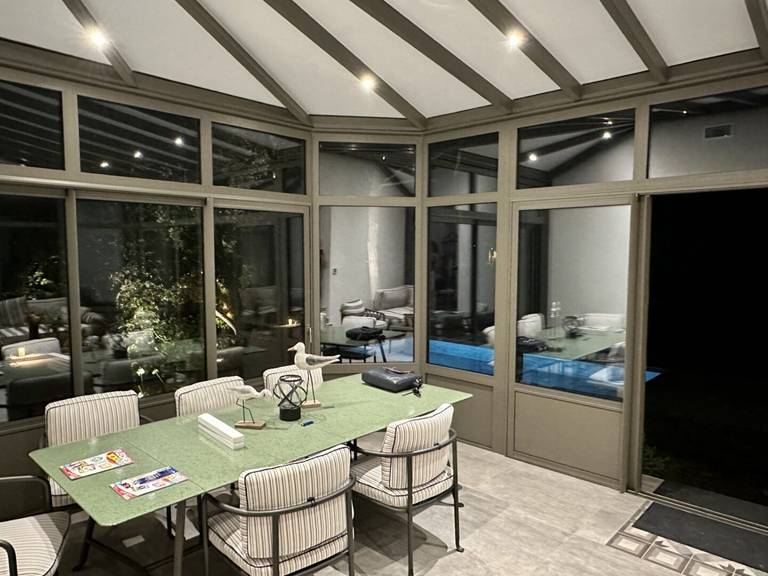Véranda (3) Véranda moderne avec toit vitré intégrant un espace de détente lumineux