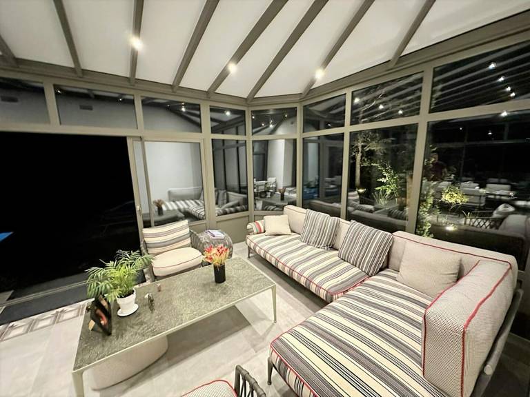 Véranda (8) Véranda moderne avec mobilier confortable et vue jardin éclairée
