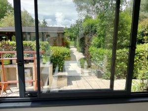 img1 Vue depuis une véranda moderne donnant sur un jardin paisible