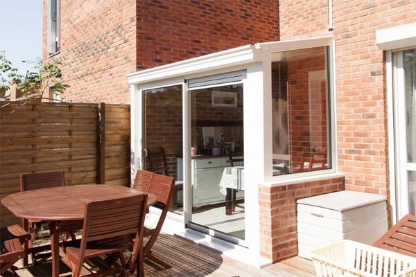 Véranda moderne avec porte vitrée donnant sur une terrasse en bois