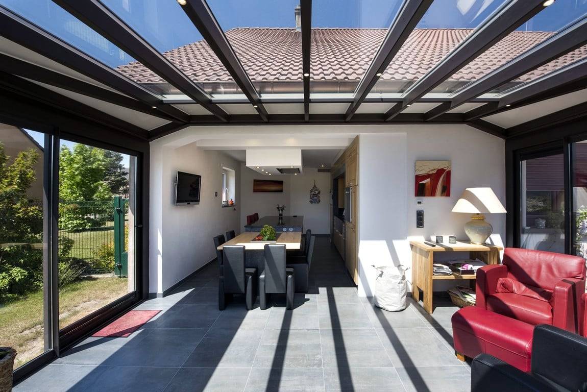 Véranda élégante avec toit en verre et mobilier contemporain