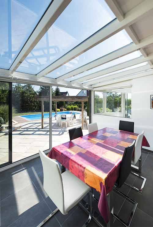 Veranda-toit-vitre-blanc-portrait table à manger devant la piscine