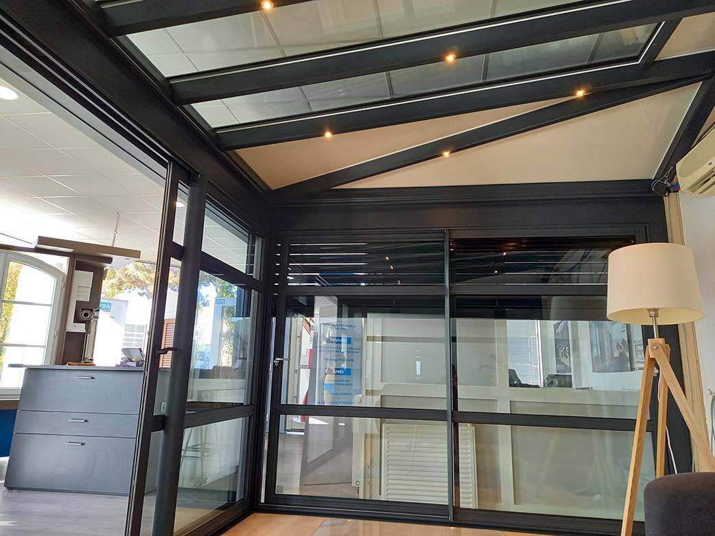 Véranda moderne avec toit en verre et structure en aluminium robuste