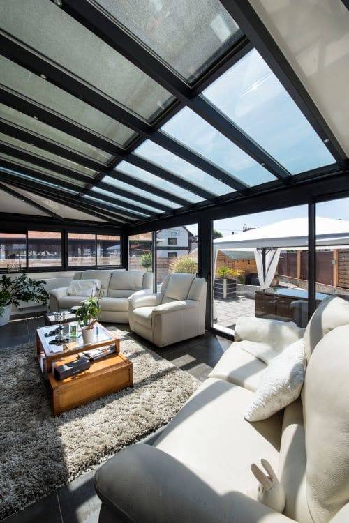 Véranda lumineuse avec mobilier contemporain et vue extérieure agréable