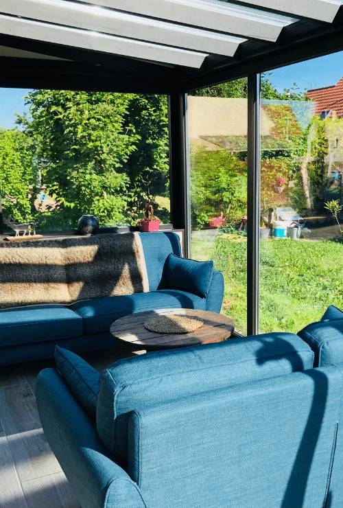 500-740-veranda-contemporain Véranda moderne avec mobilier confortable et vue sur jardin verdoyant