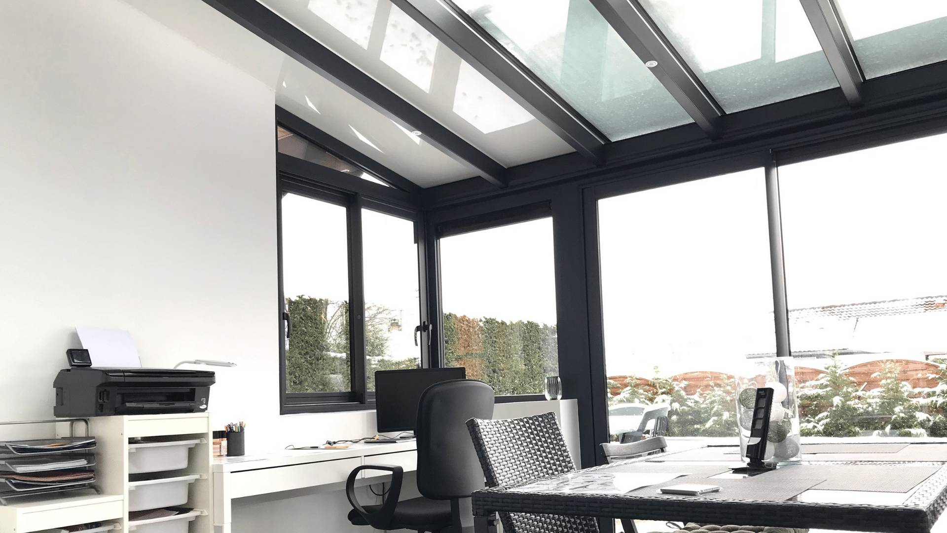 Véranda lumineuse avec bureau et table tressée pour extérieur