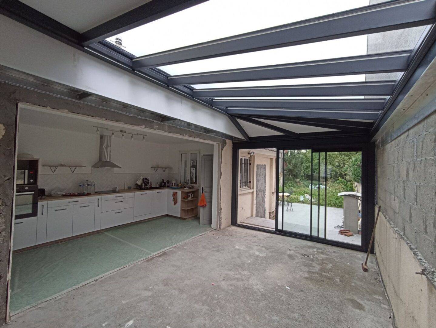 1698238512573 Véranda moderne avec toit en verre et structure métallique élégante