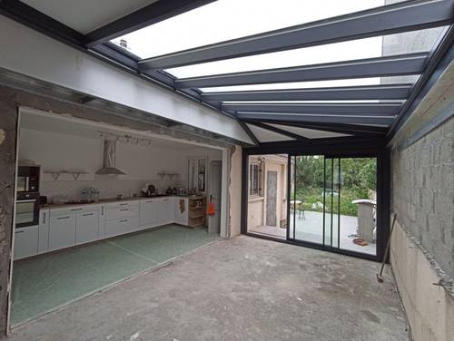 1698238512573 Véranda moderne avec toit en verre et structure métallique élégante