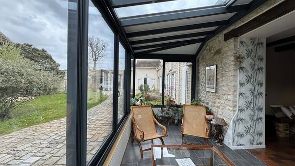 Petite véranda salon sur muret Véranda moderne avec grandes baies vitrées et espace détente lumineux