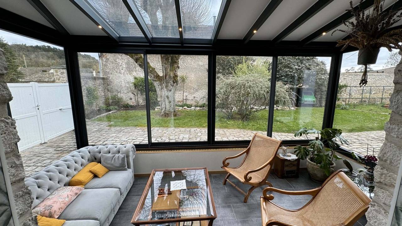 Petite véranda salon sur muret Confort moderne dans une véranda avec vue sur le jardin