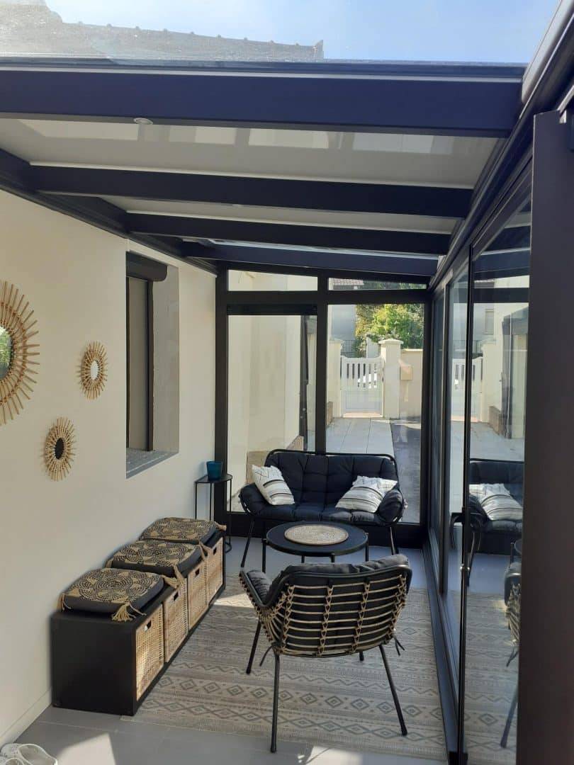 Véranda moderne aménagée avec mobilier confortable pour détente intérieure