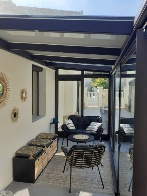 20240709_102931 Véranda moderne aménagée avec mobilier confortable pour détente intérieure