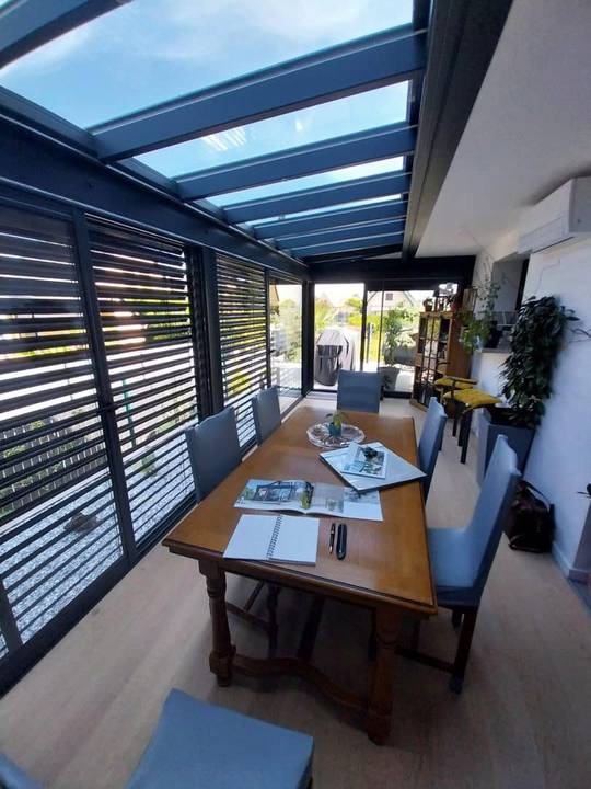 20240718_111242 Véranda moderne avec toit en verre et mobilier de jardin élégant