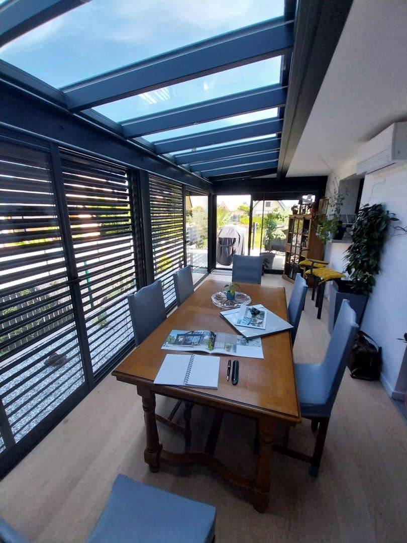 20240718_111242 Véranda moderne avec toit en verre et mobilier de jardin élégant