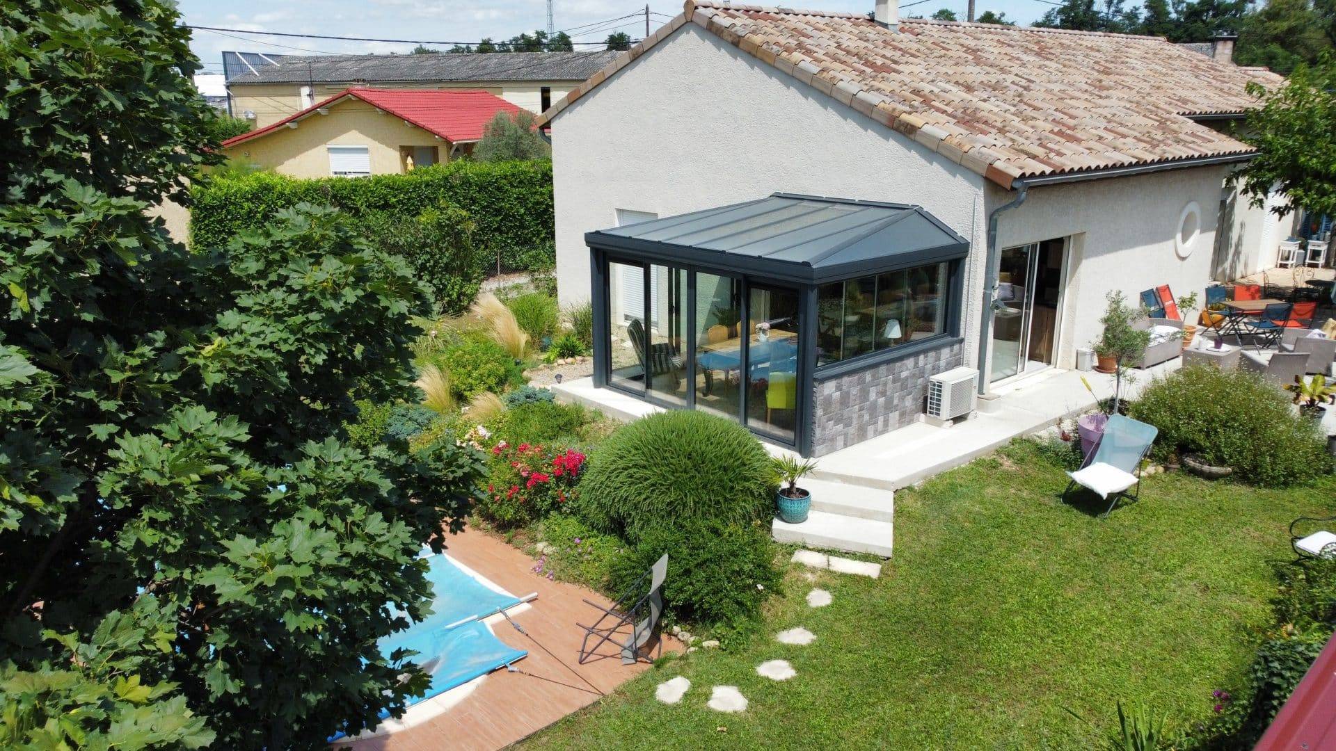 Véranda salle à manger Véranda moderne attachée à maison dans un jardin verdoyant