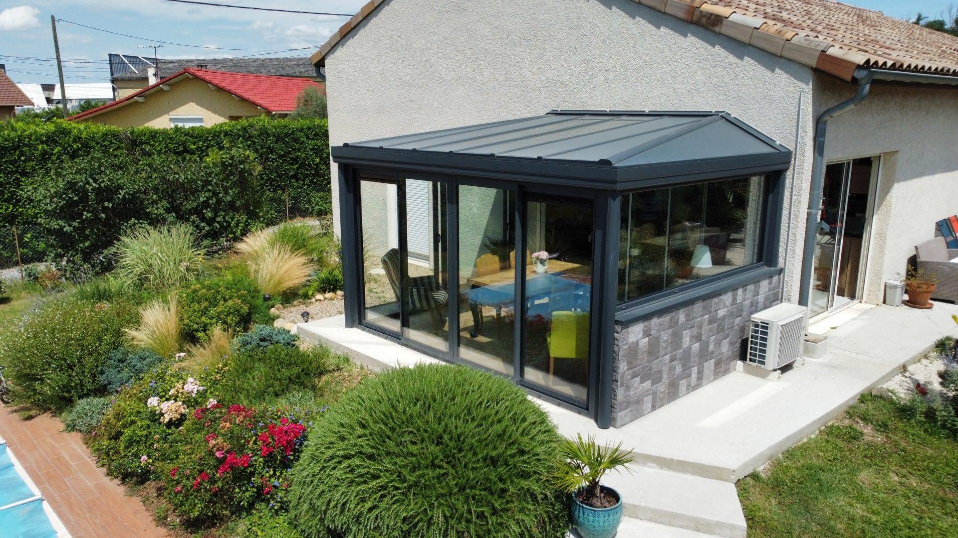 Moderne véranda avec grandes fenêtres et toit incliné en aluminium