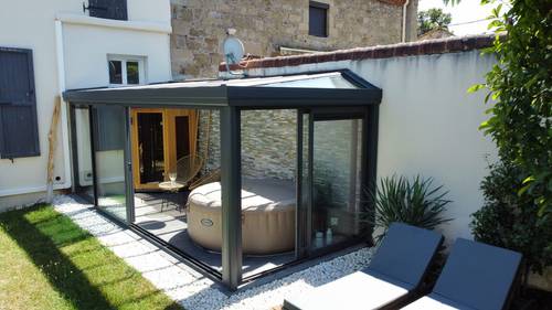 véranda avec jacuzzi Véranda moderne avec espace jacuzzi intégré dans un jardin zen