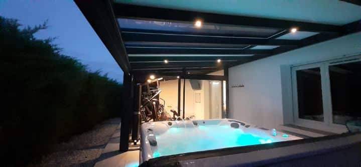 Pergola moderne abritant un jacuzzi illuminé en soirée