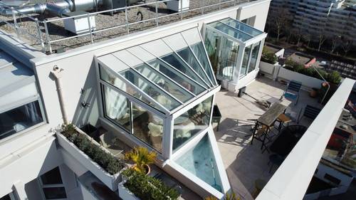 Véranda sur toit immeuble Véranda moderne en verre sur un toit-terrasse urbain spacieux
