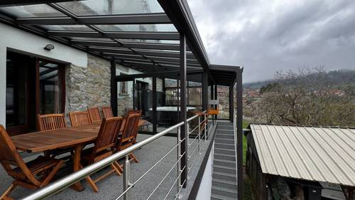 Pergola et véranda sur terrasse Véranda moderne avec mobilier en bois et vue panoramique montagne