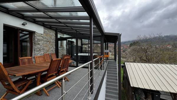 Pergola et véranda sur terrasse Véranda moderne avec mobilier en bois et vue panoramique montagne