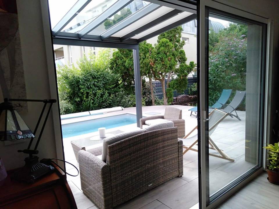 pergola à toiture fixe Pergola moderne en aluminium avec toit transparent offrant une vue piscine
