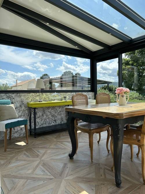 Véranda salle à manger Véranda lumineuse avec toit en verre et mobilier élégant