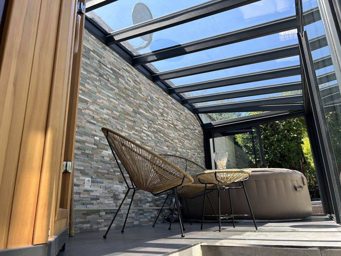 Véranda élégante avec jacuzzi et mobilier confortable pour détente extérieure