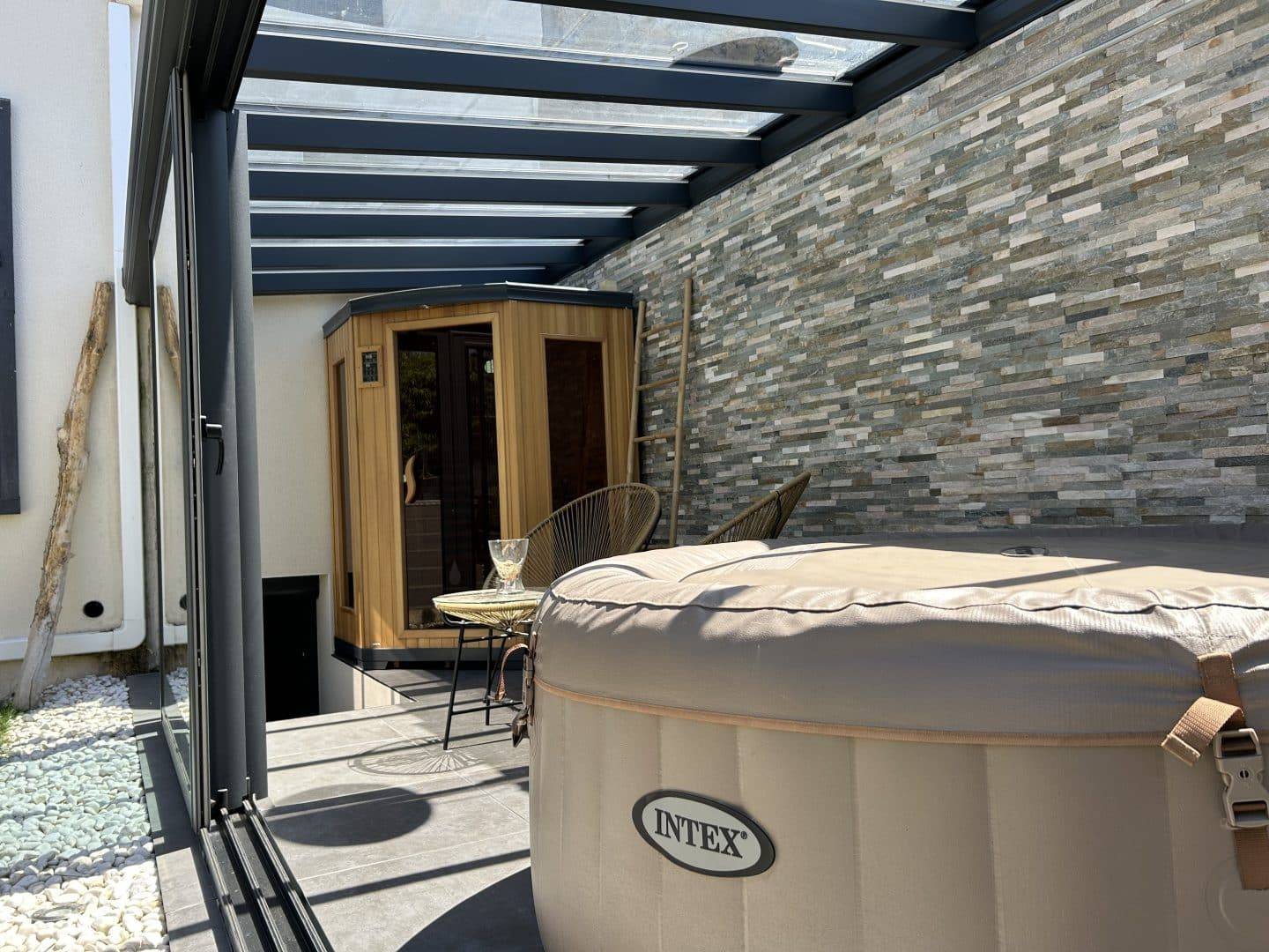 Véranda moderne en verre et métal avec jacuzzi et sauna intégré