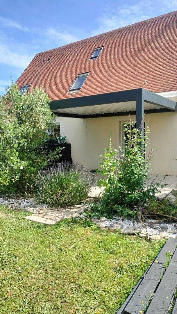 Pergola moderne adossée à une maison avec jardin verdoyant