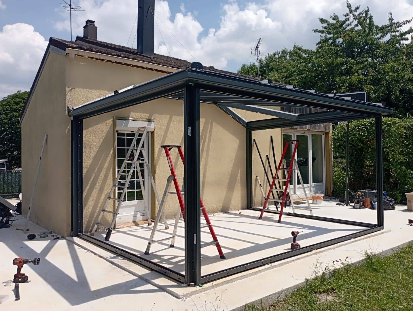 Construction de véranda en aluminium adossée à une maison.