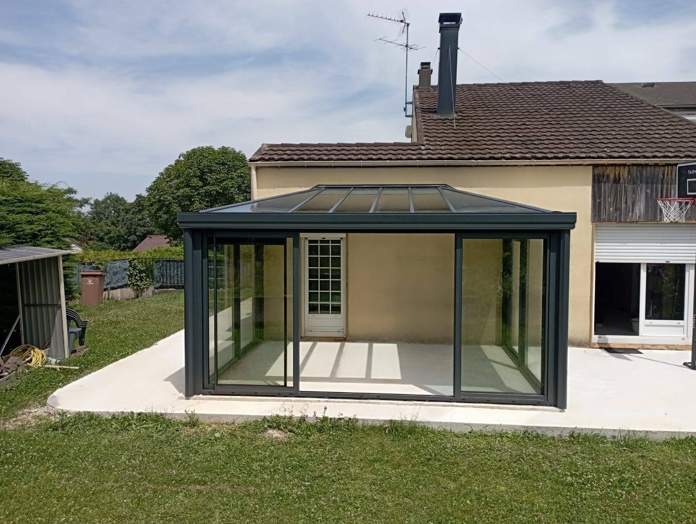 Véranda moderne en verre et aluminium attachée à une maison
