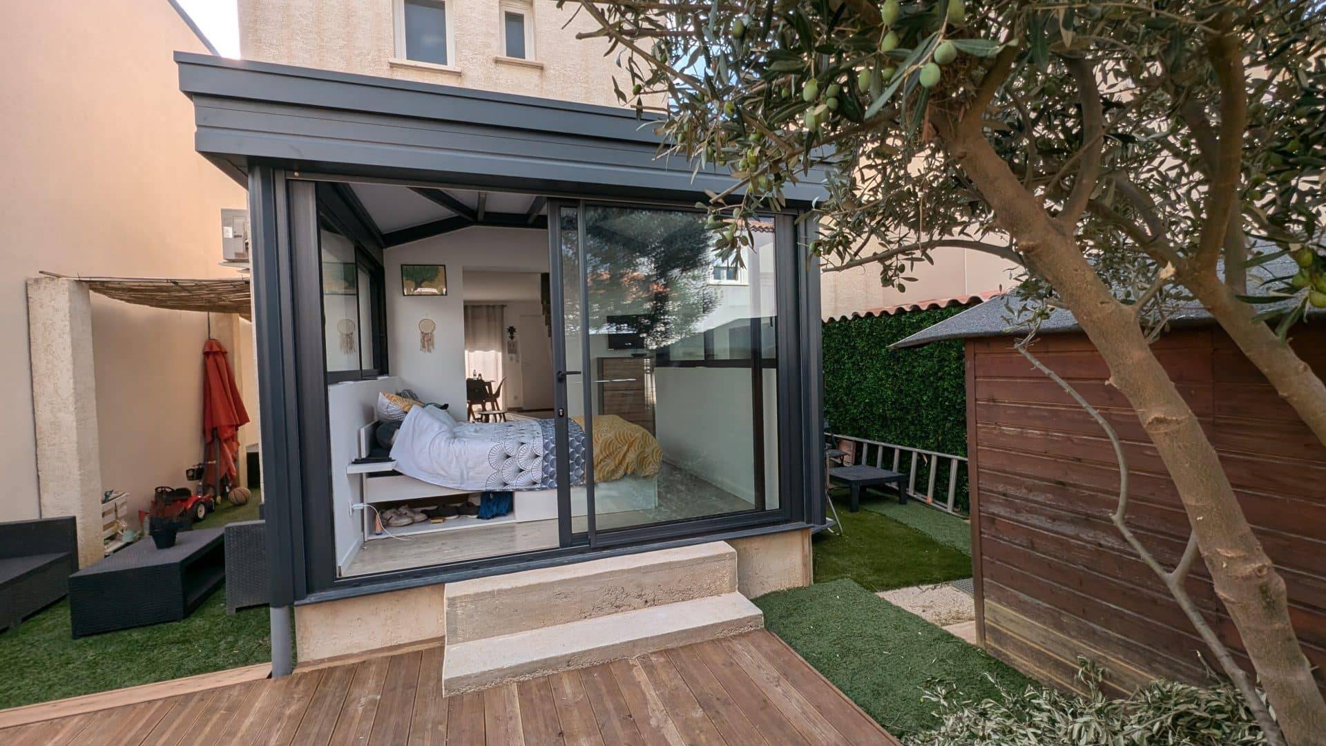 Véranda moderne aménagée comme une chambre supplémentaire.