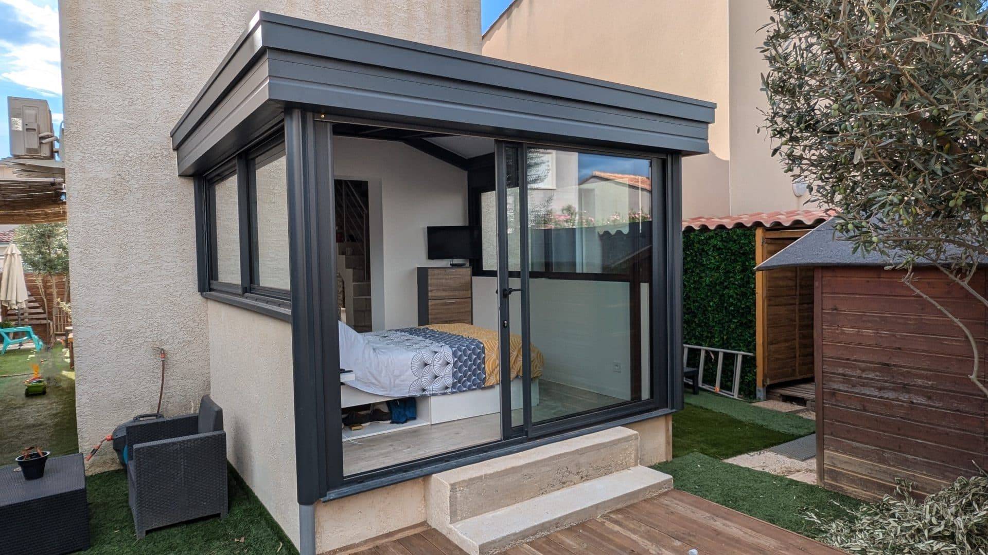 Véranda moderne avec grandes baies vitrées et toit plat