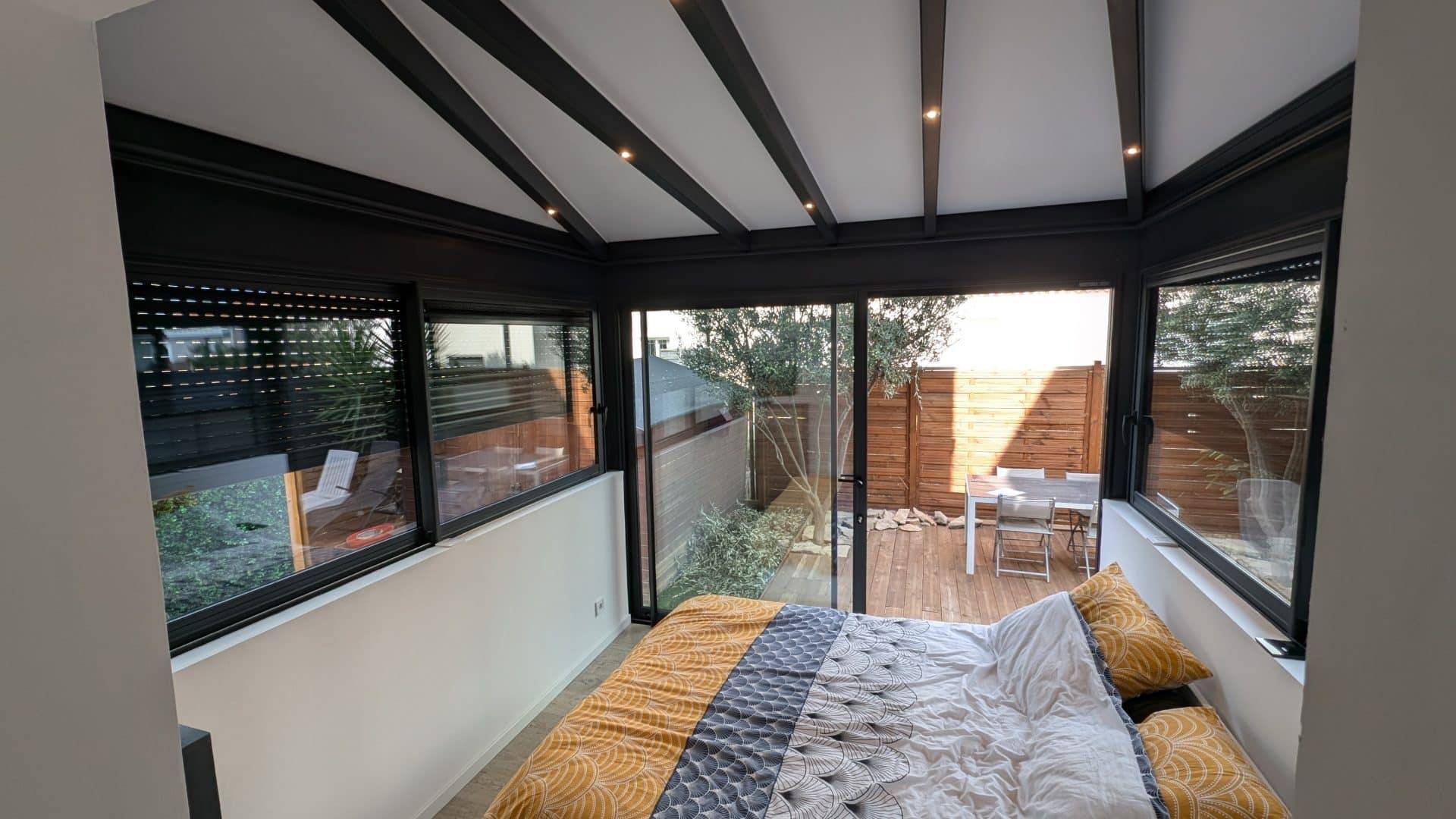 Véranda moderne attenante à une chambre avec vue sur jardin