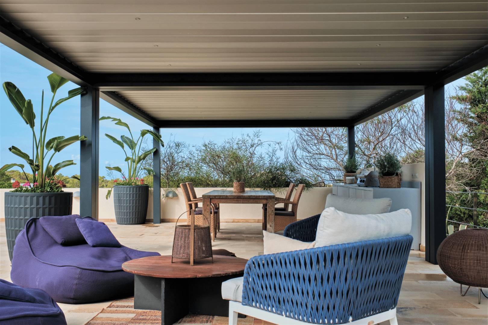 Pergola moderne avec mobilier de jardin et plantes vertes luxuriantes