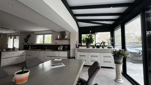 Véranda extension cuisine Véranda moderne avec plantes vertes et mobilier contemporain
