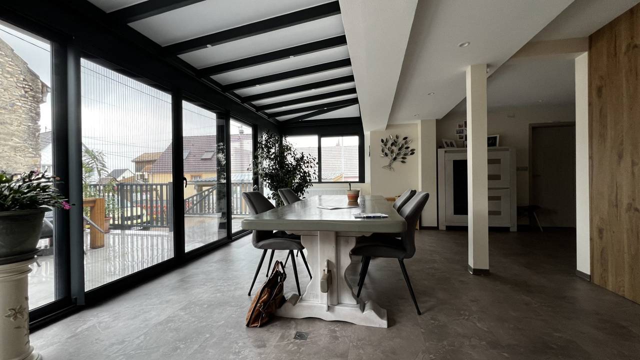 Véranda extension salle à manger Véranda lumineuse avec vue extérieure et mobilier moderne