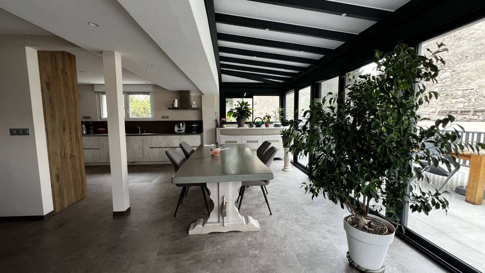 Véranda moderne et lumineuse aménagée comme salle à manger verdoyante