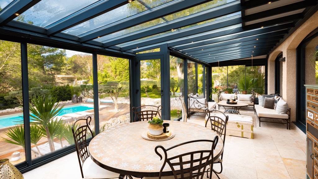 Véranda moderne avec mobilier de jardin intégré et vue piscine