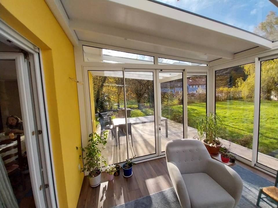 20241120_134738 Spacieuse véranda moderne avec vue sur jardin verdoyant et mobilier confortable