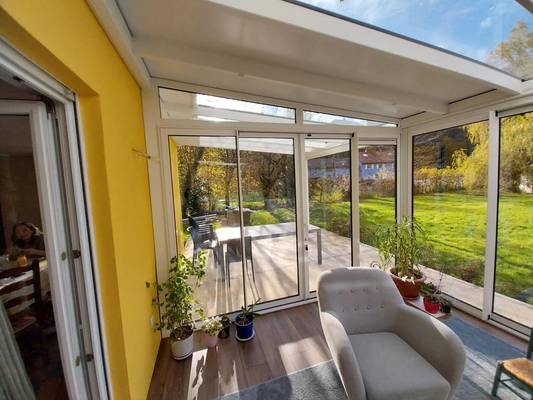 20241120_134738 Spacieuse véranda moderne avec vue sur jardin verdoyant et mobilier confortable