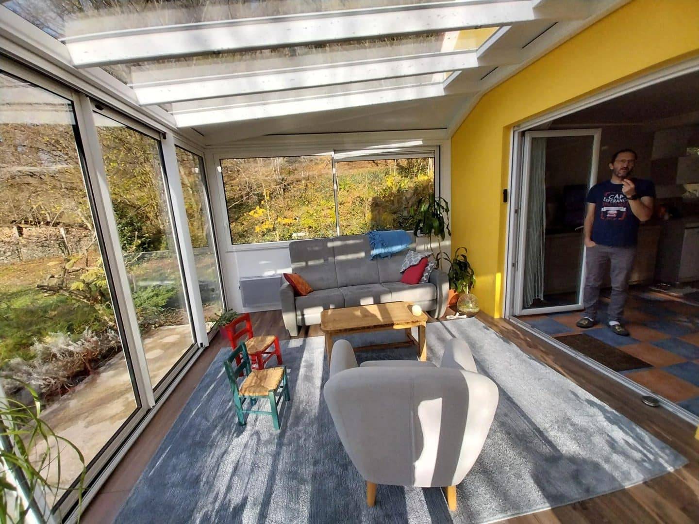 Véranda lumineuse avec vue sur le jardin et fauteuils confortables