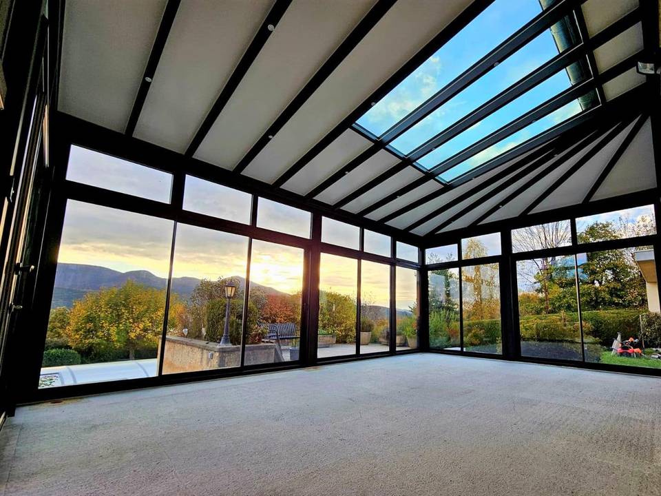 3841933269158667157 Véranda moderne avec vue panoramique sur jardin et montagnes