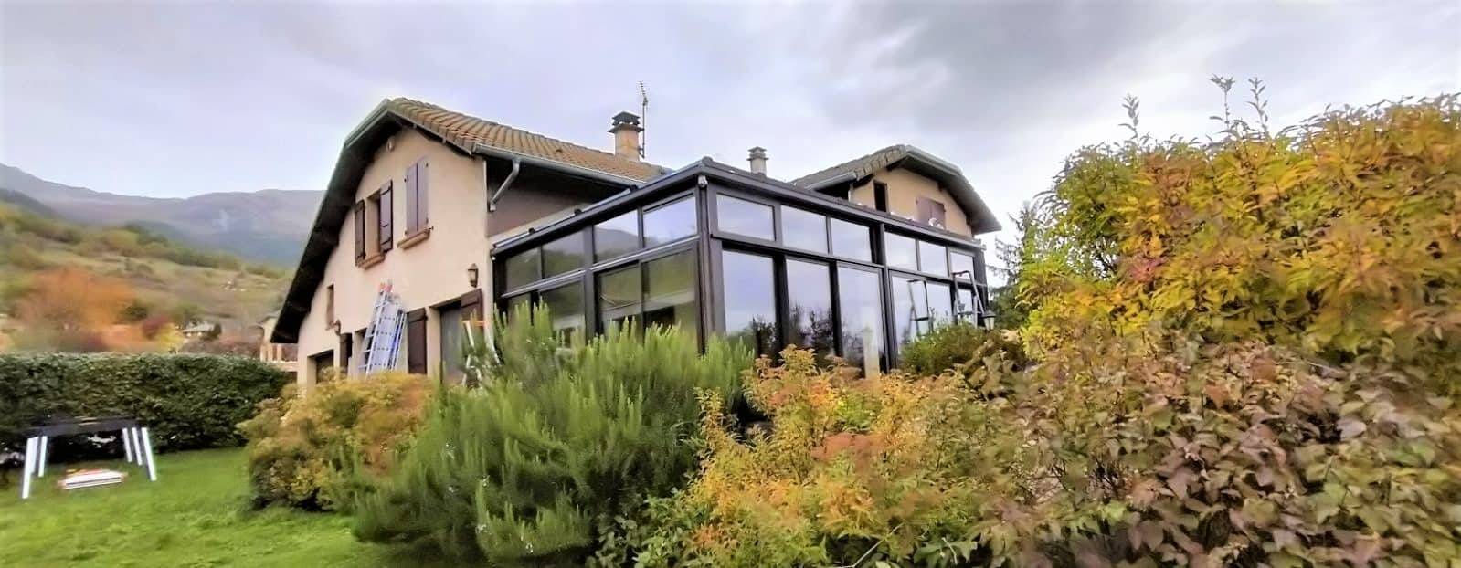 Véranda moderne en verre adossée à une maison champêtre